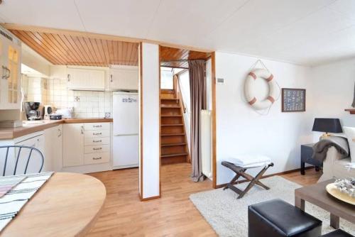 a kitchen and a living room with white appliances at Houseboat Captain's Quarters in Harbour Amsterdam in Amsterdam