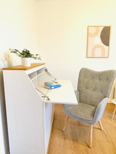 a white desk with a chair and a plant at Kreativer Rückzugsort in der Burgenstadt Schlitz in Schlitz