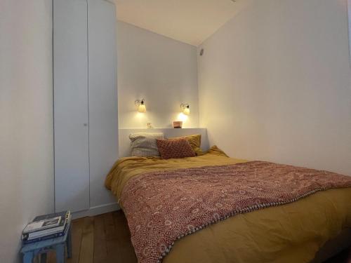 - une chambre avec un lit et deux lumières sur le mur dans l'établissement Superbe appartement proche Jardins du Luxembourg Paris, à Paris