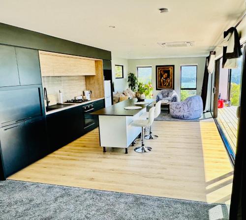 a kitchen with black cabinets and a table and chairs at Stunning house with amazing view in Diamond Harbour