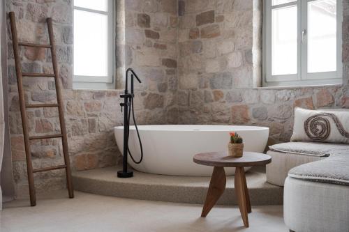 a bathroom with a white bath tub and a ladder at Horizon Suites Milos in Paliochori