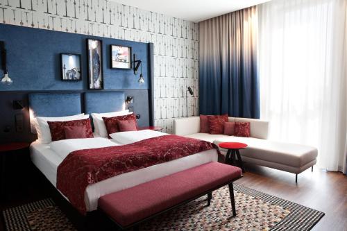 a bedroom with a large bed and a couch at Hotel Indigo Berlin - East Side Gallery in Berlin