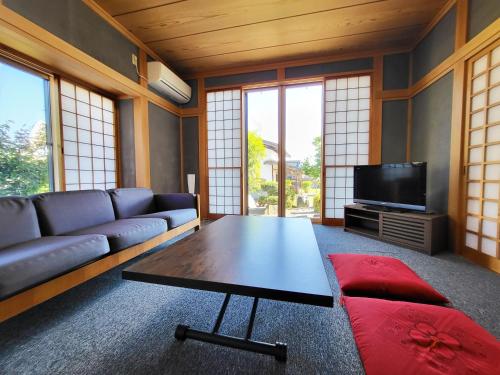 a living room with a couch and a coffee table at 貸別荘たまゆら in Kawaba