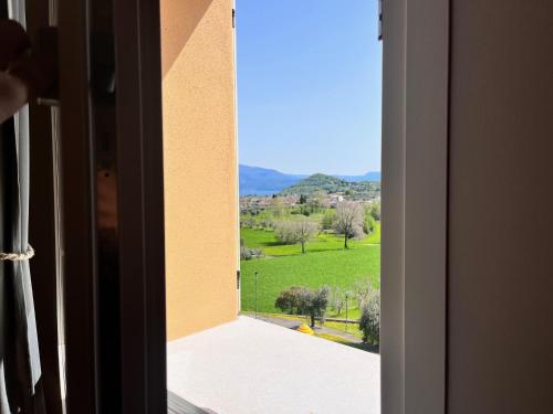 an open window with a view of a green field at Antica Corte - Lake view in Montinelle