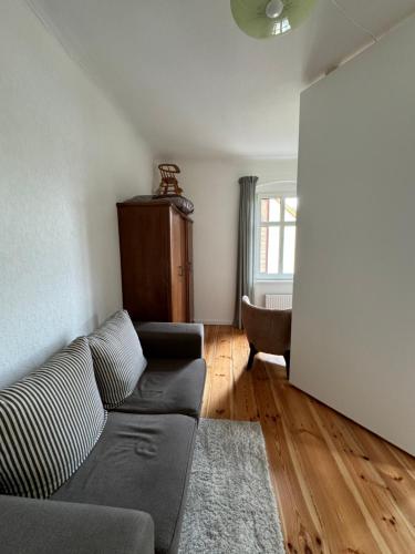a living room with a couch and a chair at Viki54 FeWo04 "hereinspaziert", Monteurs- und Ferienwohnung in Velten