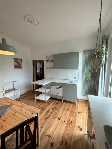 a kitchen with a white desk and a wooden floor at Viki54 FeWo04 "hereinspaziert", Monteurs- und Ferienwohnung in Velten