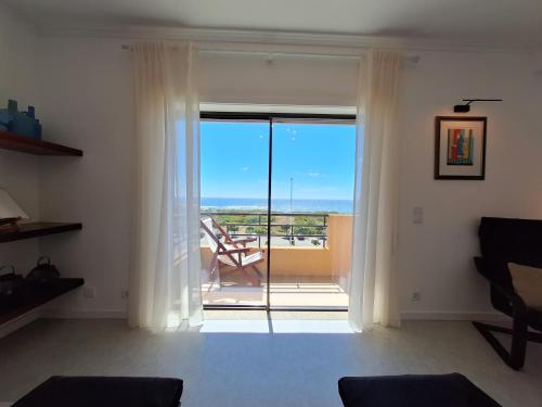 a living room with a sliding glass door to a balcony at Mostarda Boutique Apartment in Vila do Conde