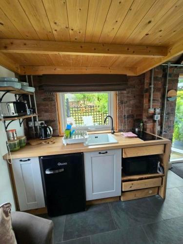 a kitchen with a sink and a counter top at La'al Cabin, tiny home, unique space Eden Valley Cumbria in Brampton