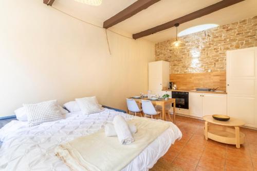 une chambre avec un grand lit et une table dans l'établissement Le Petit Saint Esprit - Centre Ville - Calme - Lumineux - Fibre, à Aix-en-Provence
