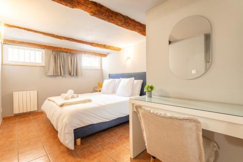 une chambre avec un lit avec un miroir et un bureau dans l'établissement Le Petit Saint Esprit - Centre Ville - Calme - Lumineux - Fibre, à Aix-en-Provence
