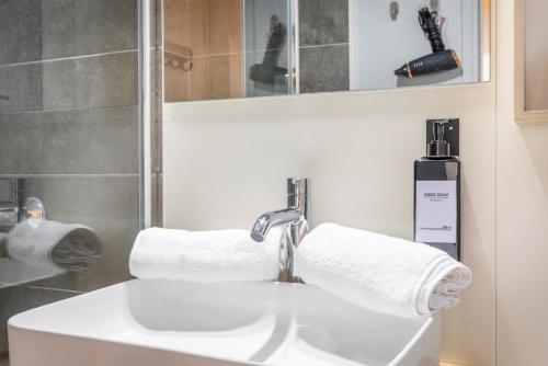 La salle de bains est pourvue d'un lavabo et de serviettes. dans l'établissement Le Petit Saint Esprit - Centre Ville - Calme - Lumineux - Fibre, à Aix-en-Provence