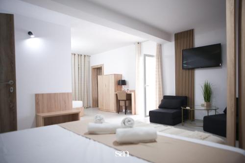 a bedroom with a bed and a living room with a couch at Hotel San Međugorje in Čitluk