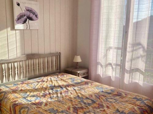 une chambre avec un lit et une fenêtre dans l'établissement Charmant F2 avec Balcon et Parking à 50m des Thermes, Centre-Ville - Animaux Acceptés - FR-1-703-125, à Amélie-les-Bains-Palalda