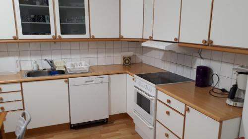 a kitchen with white cabinets and white appliances at Fjordshelter vintage townhouse in Tysso