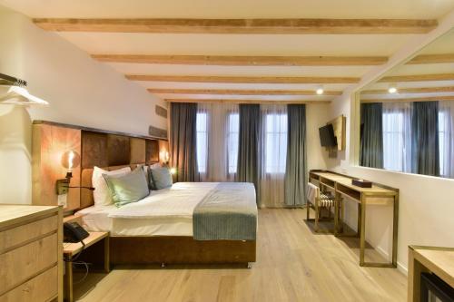 a hotel room with a bed and a desk at Hotel Rousseau in Geneva