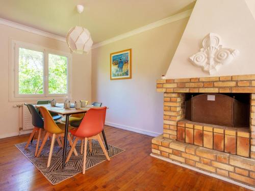 une salle à manger avec une table et une cheminée dans l'établissement Maison charmante à Carnac, 3 pièces, jardin, à 300m de la Rivière de Crac'h - FR-1-477-247, à Carnac