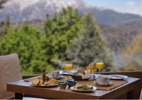 a table with plates of food and two glasses of wine at Huenú by DOT Boutique in Villa La Angostura