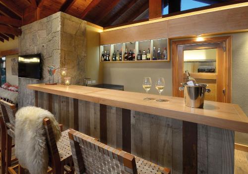 a bar in a restaurant with two glasses of wine at Huenú by DOT Boutique in Villa La Angostura