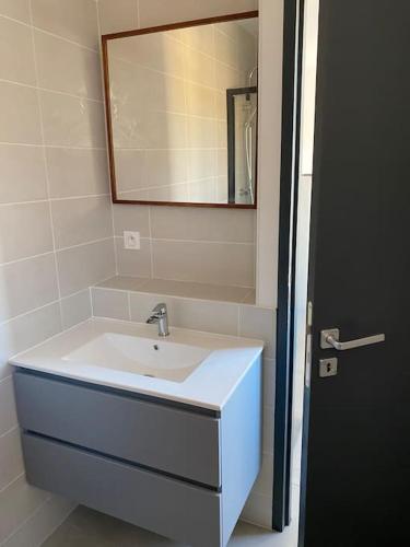 une salle de bain avec un lavabo et un miroir dans l'établissement Appartement T2 centre ville à 400m de la plage, à Valras-Plage