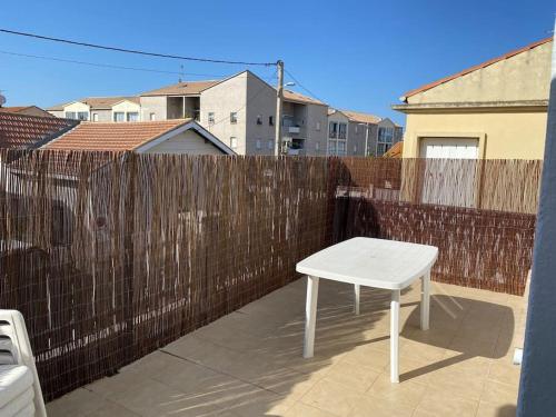 une table blanche assise au-dessus d'un balcon dans l'établissement Appartement T2 centre ville à 400m de la plage, à Valras-Plage