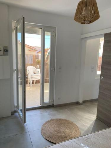une pièce avec des portes coulissantes en verre et un tapis au sol dans l'établissement Appartement T2 centre ville à 400m de la plage, à Valras-Plage