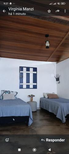 a bedroom with two beds and a wooden ceiling at CASINHA AZUL/PIRINOPOLIS in Pirenópolis