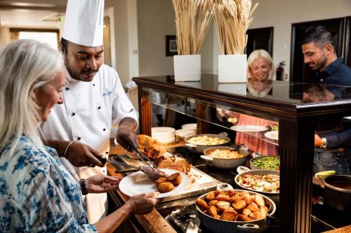 a group of people preparing food in a kitchen at Pomme d'Or Hotel in Saint Helier Jersey