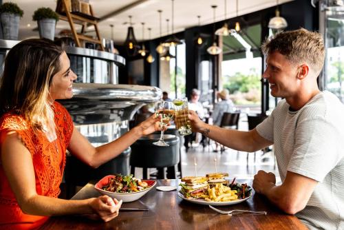 a man and woman sitting at a table with wine glasses at Pomme d'Or Hotel in Saint Helier Jersey