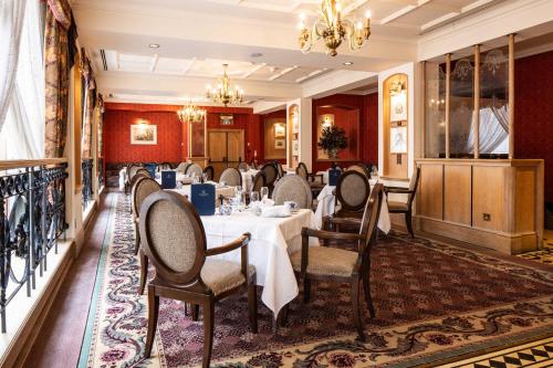 a dining room with tables and chairs and a chandelier at Pomme d'Or Hotel in Saint Helier Jersey