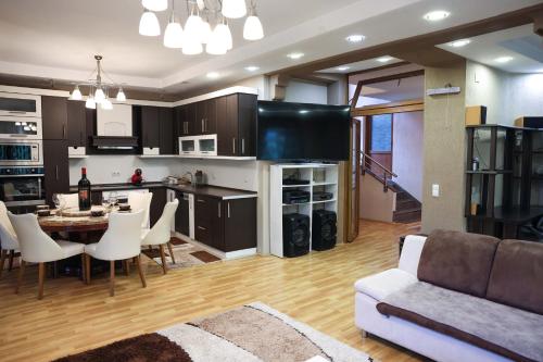 a kitchen and living room with a couch and a table at Mountain Garden House in Prizren