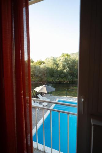 a view of a pool from a balcony with an umbrella at Villa Paradise On The River in Blagaj