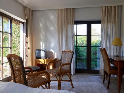 a hotel room with a bed and a desk and chairs at Ferienwohnung im Hochland in Kloster