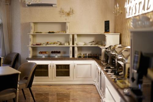 une cuisine avec des armoires et des chaises blanches dans un restaurant dans l'établissement Mountain Krystal, à Bukovel