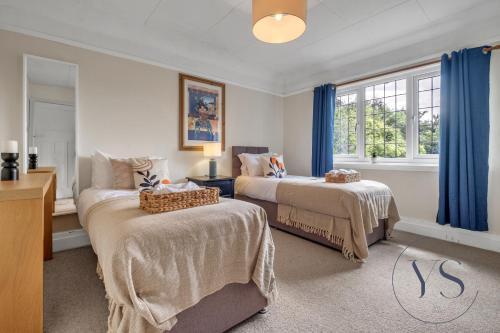 1 dormitorio con 2 camas y cortinas azules en 4BR Cottage, Parking, NEC, Birmingham Airport, en Birmingham