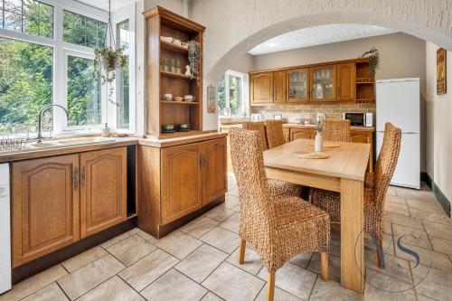 cocina con mesa de madera, sillas y fregadero en 4BR Cottage, Parking, NEC, Birmingham Airport, en Birmingham