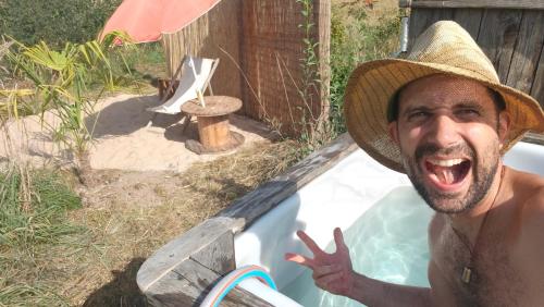 a man wearing a straw hat in a bathtub at Nisihof, Buurenzimmer Family or Single in Oberkirch