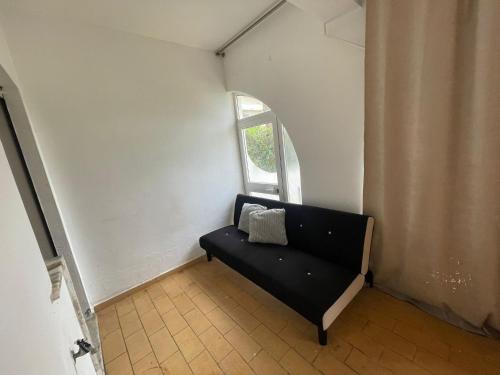 a black couch in a room with a window at Amazing Studio Flat Albufeira in Albufeira