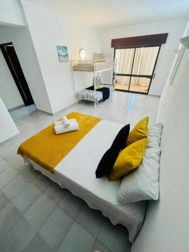 a bedroom with a large bed with yellow pillows at Amazing Studio Flat Albufeira in Albufeira