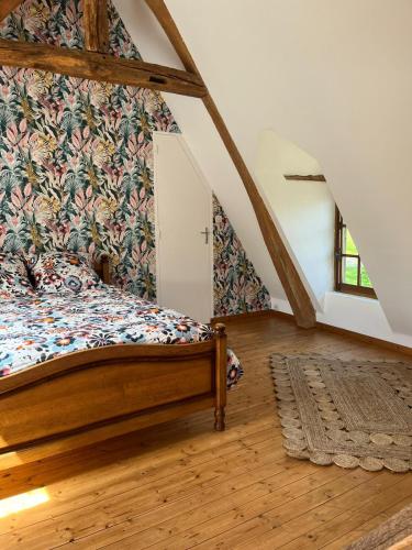 - une chambre avec un lit orné d'un mur fleuri dans l'établissement Chez Catherine, à Saint-Michel-dʼHalescourt