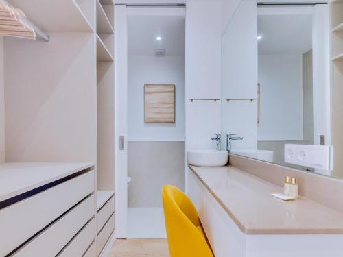 クアルテイラにあるAL Apartamento Alsolのバスルーム(シンク、黄色い椅子付)