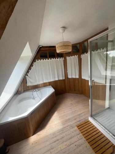 La salle de bains mansardée est pourvue d'une baignoire et d'une douche. dans l'établissement Chez Catherine, à Saint-Michel-dʼHalescourt