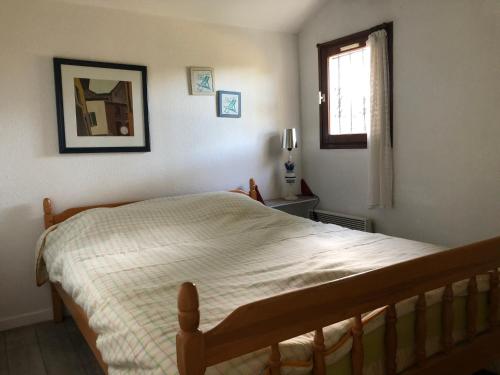 une chambre avec un grand lit avec une fenêtre dans l'établissement Charmante maison dans les pins proche de la plage, à Saint-Cyprien