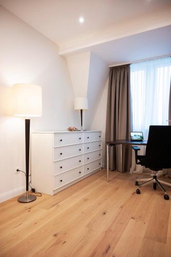 a bedroom with a desk and a dresser with a table and a chair at Kleiner Rosengarten in Mannheim