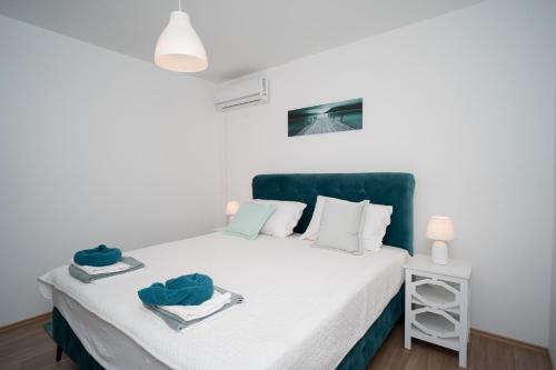 a bedroom with a bed with a green headboard at Villa Paradise On The River in Blagaj