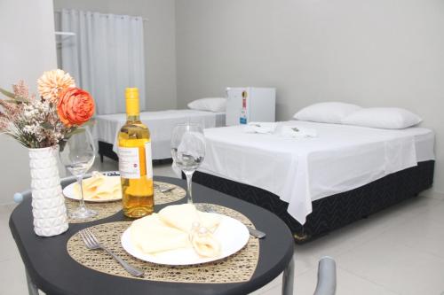 a table with two glasses and a bottle of wine at Liziane Souza da Silva in Catarina