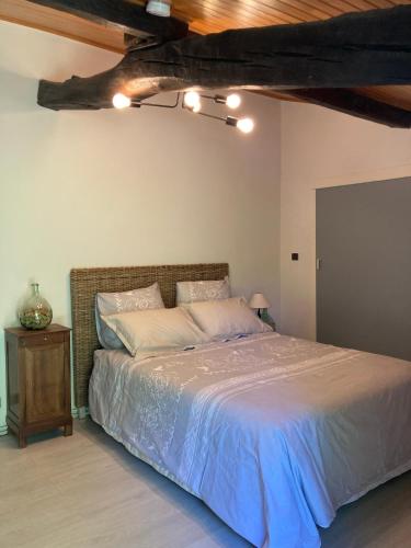 une chambre avec un grand lit avec un plafond en bois dans l'établissement Maison DAN'INN, à Saint-Morillon