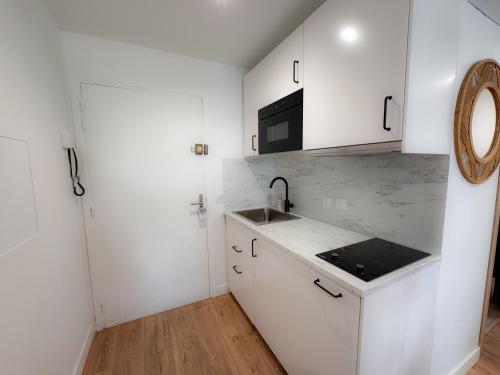 une cuisine blanche avec un évier et un micro-ondes dans l'établissement By the beach, Sea View, brand new, à Cagnes-sur-Mer