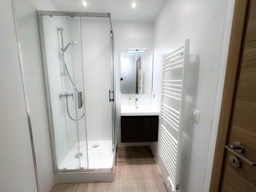 une salle de bain blanche avec une douche et un lavabo dans l'établissement By the beach, Sea View, brand new, à Cagnes-sur-Mer