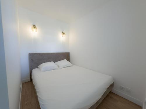 - un lit blanc dans une chambre blanche avec deux oreillers dans l'établissement By the beach, Sea View, brand new, à Cagnes-sur-Mer