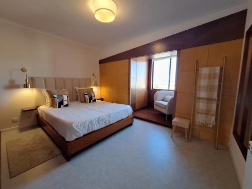 una camera da letto con un letto grande e una sedia di Mostarda Boutique Apartment a Vila do Conde